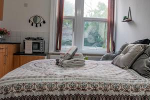 Un dormitorio con una cama con una toalla. en Bv Comfy Studio At Maningham Lane Bradford en Bradford