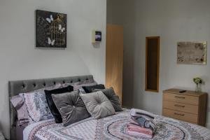 a bedroom with a bed and a wooden dresser at Bv Comfy Studio At Maningham Lane Bradford in Bradford