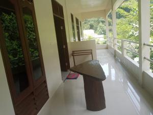 a bench sitting on the front porch of a house at Raja Guest House - Jungle Trekking & Tours Bukit Lawang Sumatra in Bukit Lawang