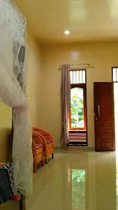 a living room with a bed and a window at Raja Guest House - Jungle Trekking & Tours Bukit Lawang Sumatra in Bukit Lawang