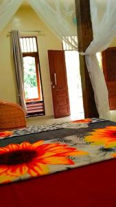 a bedroom with a bed with a colorful comforter at Raja Guest House - Jungle Trekking & Tours Bukit Lawang Sumatra in Bukit Lawang