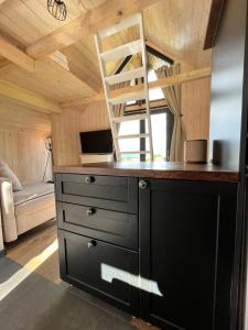 eine Küche mit einem Schreibtisch und einer Leiter in einem Zimmer in der Unterkunft Bramble Tiny House in Zărneşti