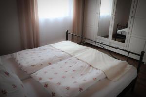 a bed with a white comforter and a mirror at Ferienhaus Schneckenheisl in Mindelstetten