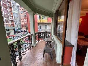 a balcony with a table and a chair on it at Guesthouse Parnavaz Mepe in Batumi