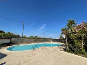 - une piscine dans une cour avec des palmiers dans l'établissement Splendide appartement de charme avec patio, parking et plage à 3 minutes, à Biarritz