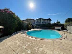 una piscina en un patio con una casa al fondo en Splendide appartement de charme avec patio, parking et plage à 3 minutes, en Biarritz