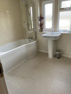 a bathroom with a sink and a bath tub and a sink at Cotswolds Luxury House in Central Bourton Large Sleeps 2-11. Pet Friendly. in Bourton on the Water