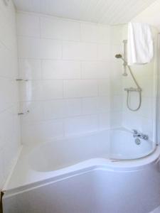 ein weißes Bad mit einer Badewanne und einer Dusche in der Unterkunft Cozy 4 Bedroom House in Smethwick with 4 bathrooms perfect for contractors and families in Birmingham