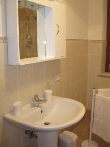 bagno con lavandino e specchio di La Casetta Arancione appartamento a Stroncone