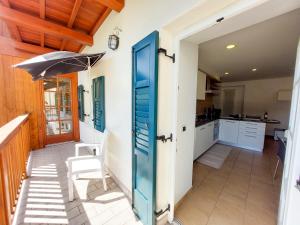 a door leading into a kitchen with a table and an umbrella at Appartamento Diana in Cavalese