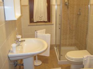 a bathroom with a sink and a toilet and a shower at La Casetta Arancione appartamento in Stroncone