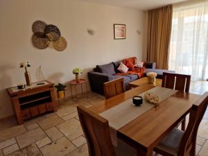 uma sala de estar com uma mesa e um sofá em HC Apartments Kaliakria em Topola