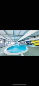 a large swimming pool with blue water in a building at Yogi's Space in Birchington