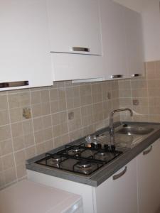 a kitchen with a stove and a sink at La Casetta Arancione appartamento in Stroncone