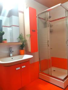 ein orangefarbenes Badezimmer mit einem Waschbecken und einer Dusche in der Unterkunft Seaside mountain view Golden Mar villa in Paránimfoi