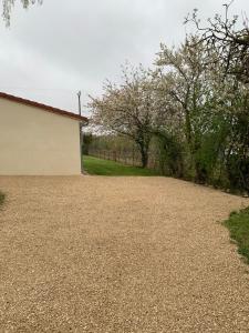 a gravel driveway with a building and trees at loge de la Besnardière in Mareuil-sur-Cher