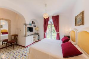 a bedroom with a large white bed and a window at Hotel Giordano in Ravello