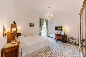 Dormitorio con cama, escritorio y TV en Hotel Giordano, en Ravello