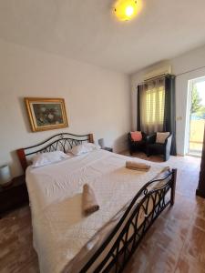 a bedroom with a large bed and a living room at Apartmani Levarda in Trogir