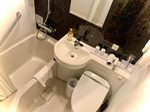 a bathroom with a toilet and a sink and a tub at Henn na Hotel Tokyo Haneda in Tokyo