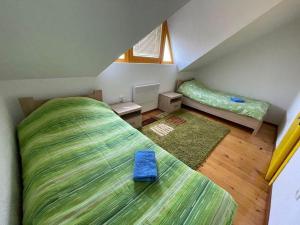 a attic bedroom with two beds and a window at Villa Lux in Žabljak