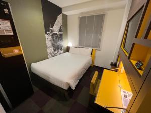 a small bedroom with a white bed in a room at Henn na Hotel Tokyo Haneda in Tokyo