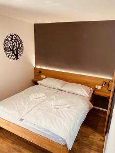 a bedroom with a bed with a tree picture on the wall at PJagodic Hotel Cerklje - 5min to Airport in Cerklje na Gorenjskem