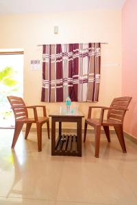 twee stoelen en een tafel in een kamer bij Dwarka Residency in Mahabalipuram