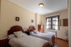 a bedroom with two beds and a window at El Jardín de Fray Diego in Zamora