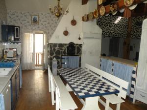 a kitchen with a checkered table and chairs in it at GRANDE MAISON FAMILIALE in Escouloubre