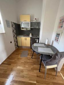 a small kitchen and dining room with a table and chairs at Apartmani Levarda in Trogir