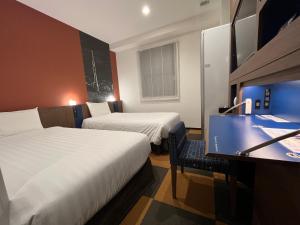 a hotel room with two beds and a desk at Henn na Hotel Tokyo Haneda in Tokyo