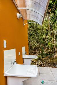 La salle de bains est pourvue d'un lavabo et de toilettes. dans l'établissement Chalés da Libélula, à Ilhabela