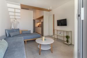 a living room with a blue couch and a table at MERA APARTMENTS in Stavros