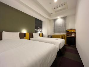 a hotel room with two beds and a window at Henn na Hotel Tokyo Haneda in Tokyo