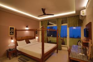 1 dormitorio con cama con dosel y ventana en Green Valley Vista, en Munnar