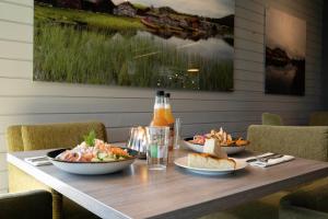 a wooden table with plates of food on it at Frich's Hotell og Spiseri Alvdal in Alvdal