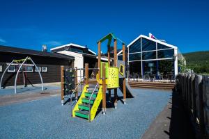 a playground with a yellow and green slide at Frich's Hotell og Spiseri Alvdal in Alvdal