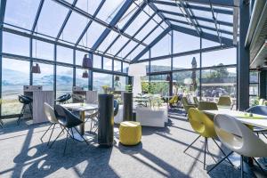 un restaurante con mesas, sillas y ventanas en Frich's Hotell og Spiseri Alvdal en Alvdal