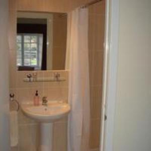 uma casa de banho com um lavatório e um espelho em Highlander Inn em Craigellachie