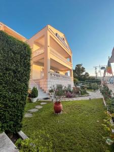 un grand bâtiment avec un jardin en face dans l'établissement Philoxenia Inn, à Thasos