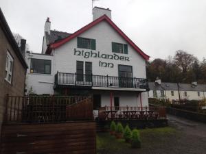 een wit huis met de wordsolkienien val erop bij Highlander Inn in Craigellachie