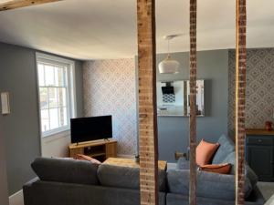 ハンティンドンにあるAspen-free parking-Grade II listed-second floor two bedrooms apartmentのリビングルーム(ソファ、テレビ付)