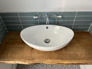 a white sink in a bathroom on a wooden floor at Aspen-free parking-Grade II listed-second floor two bedrooms apartment in Huntingdon