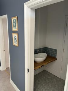 a bathroom with a white sink in a room at Aspen-free parking-Grade II listed-second floor two bedrooms apartment in Huntingdon