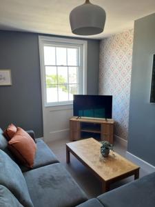 a living room with a couch and a coffee table at Aspen-free parking-Grade II listed-second floor two bedrooms apartment in Huntingdon