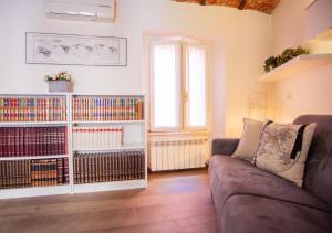 sala de estar con sofá y estantería con libros en BnButler - Alfieri, 15 - Vecchie Atmosfere, en Milán
