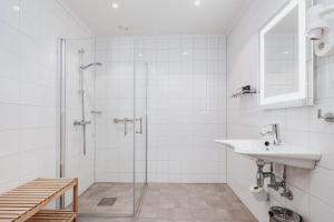 a white bathroom with a sink and a shower at Frich's Hotell og Spiseri Alvdal in Alvdal