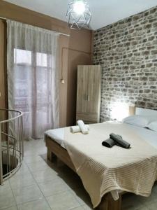 a bedroom with a bed and a brick wall at Waterway view in Galatas