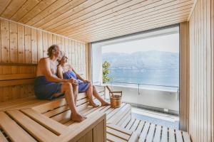 a man and a woman sitting in a sauna at Casa Berno Swiss Quality Hotel in Ascona